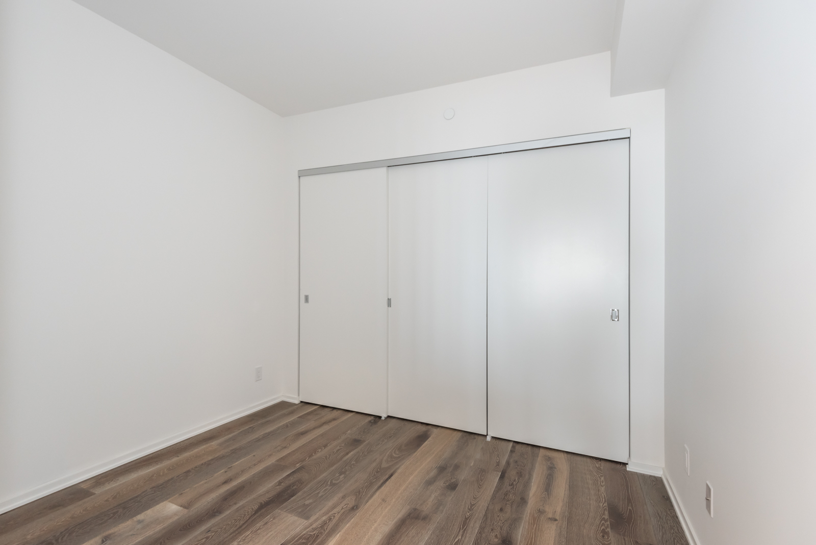 Photo of 2nd bedroom showing large closet doors.