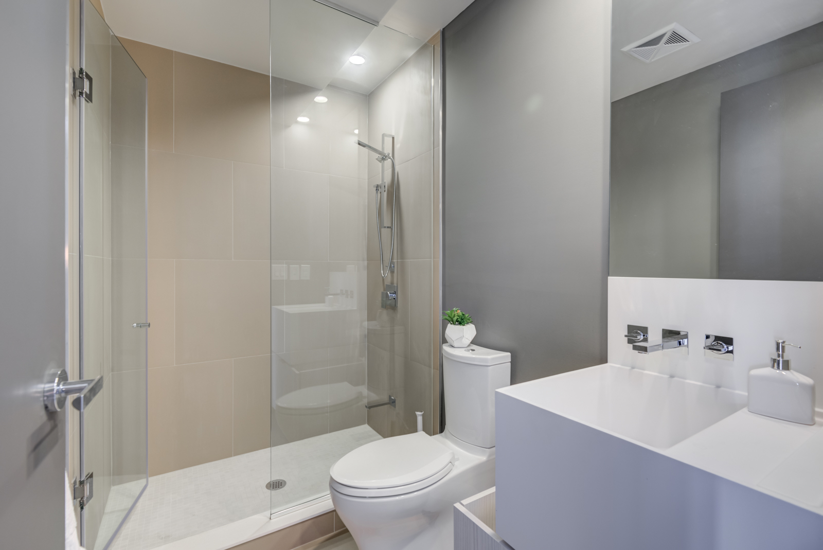 1 Bloor St E Unit 4305 bathroom with walk-in shower, large white sink, cabinets and wall-mounted faucet.