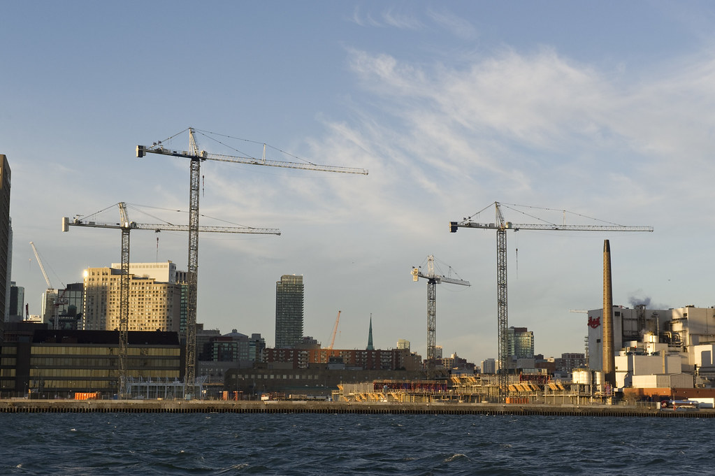 Long distance shot from Lake Ontario of 4 construction cranes on Toronto Waterfront.