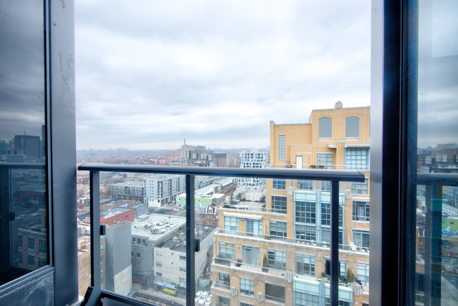 PH 101 balcony with glass panels overlooking buildings of the Fashion District.