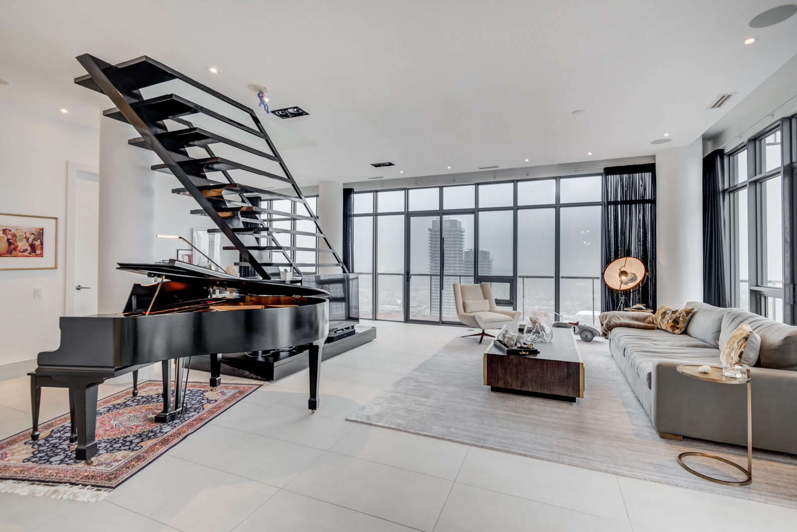 Second most expensive property with black piano, staircase, furniture in penthouse of 33 Charles St E penthouse unit.