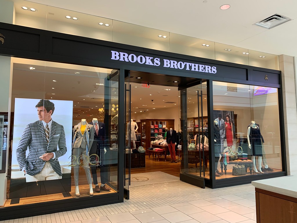 Brooks Brothers storefront display with male and female mannequins.