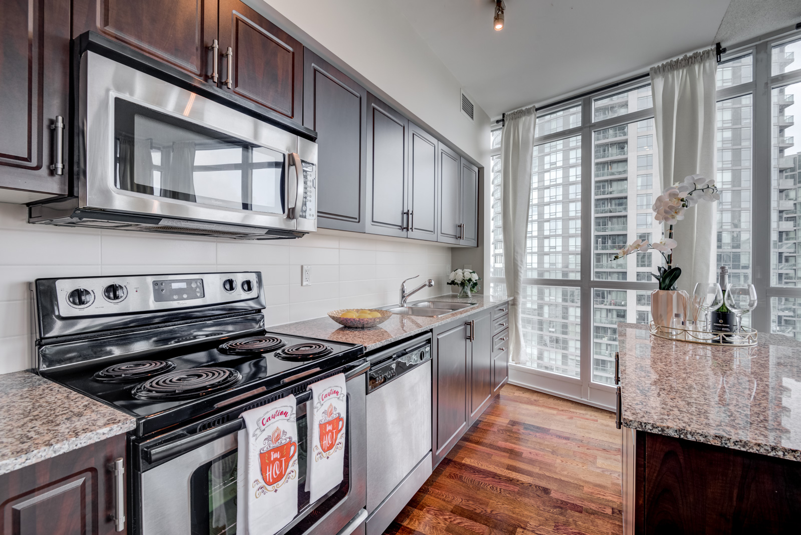 Linear kitchen and stainless oven, dishwasher and microwave at 215 Fort York Blvd Unit 2310.