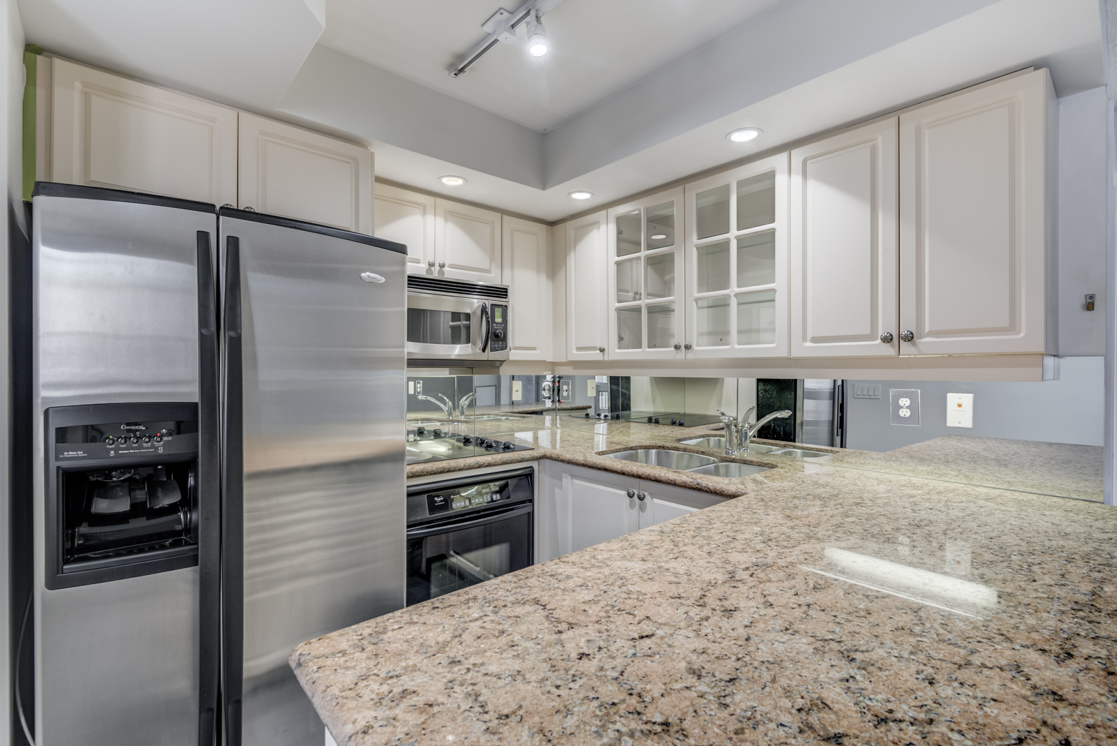 Close up of kitchen granite counter tops and silver appliances.