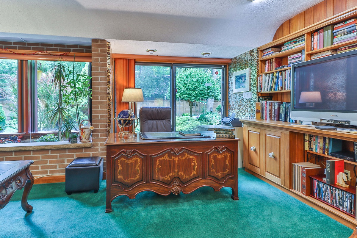 Library with indoor plants and huge bay windows.