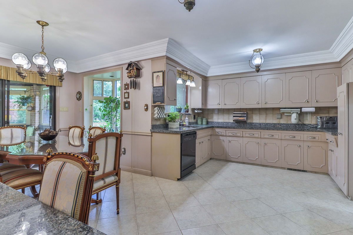Well lit kitchen with chandeliers, ceiling lamps and windows.