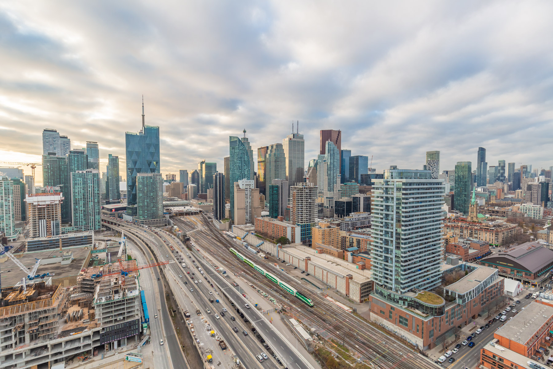 Toronto skyline evening buildings roads railways Toronto skyline with buildings, CN Tower needle, construction, highways and Go Train.