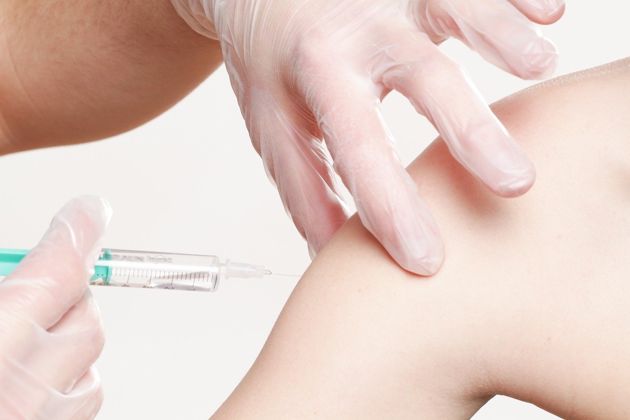Close up of arm receiving vaccines.