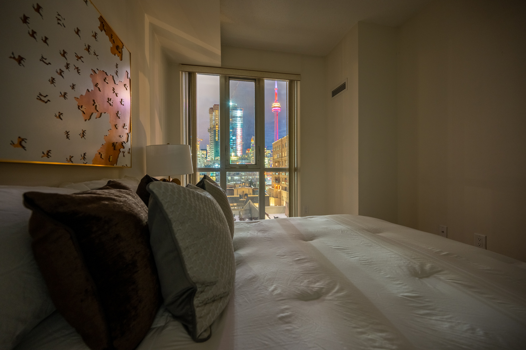 View of red CN Tower lights through window of 560 Front St W master bedroom windows.