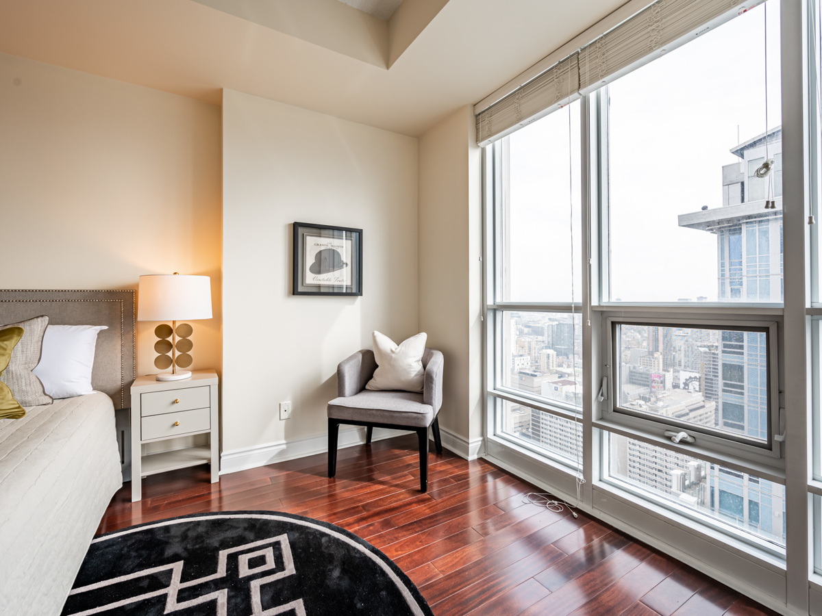condo bedroom floor to ceiling windows Toronto view Bright floor-to-ceiling windows with view of downtown Toronto.