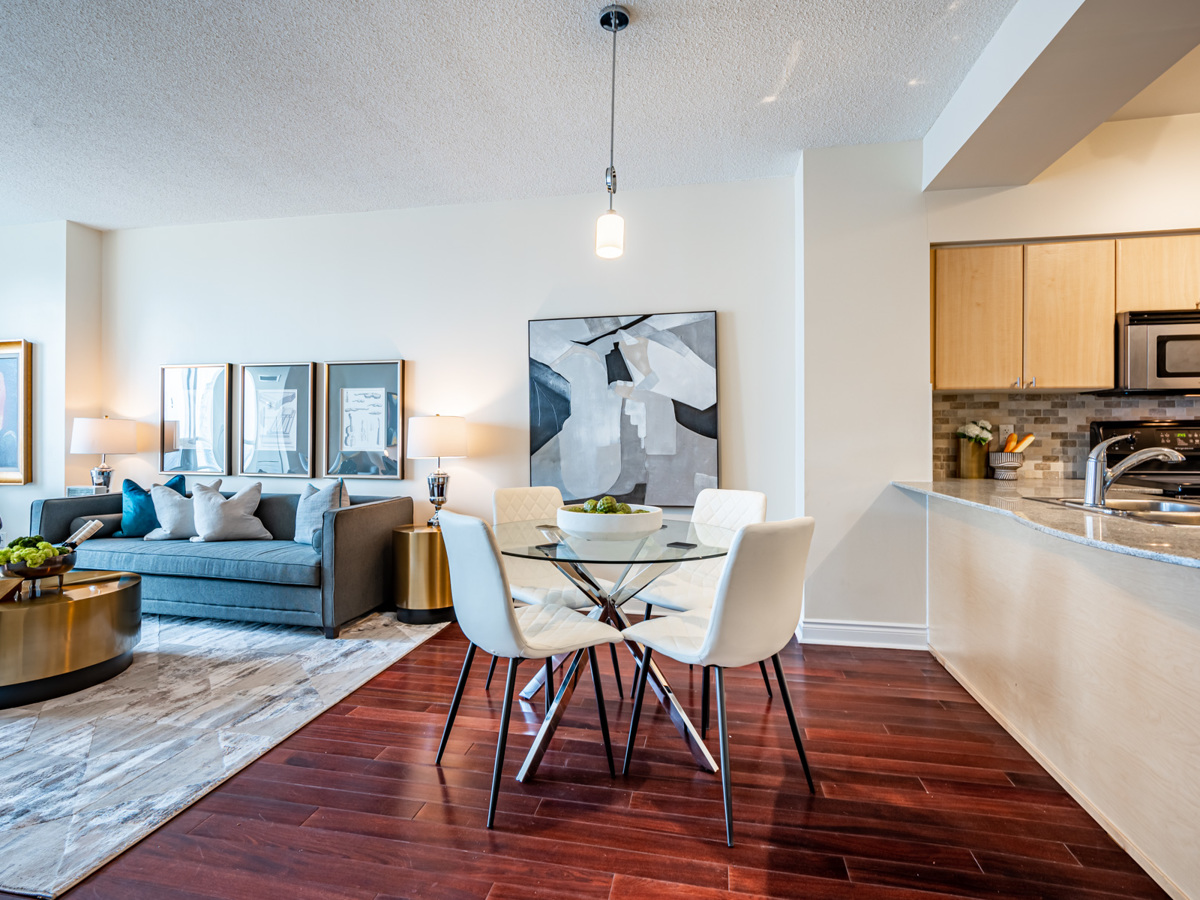 763 bay st unit 4705 dining room pendant light red hardwood floors Condo with dark hardwood floors, brown door and light-coloured walls.