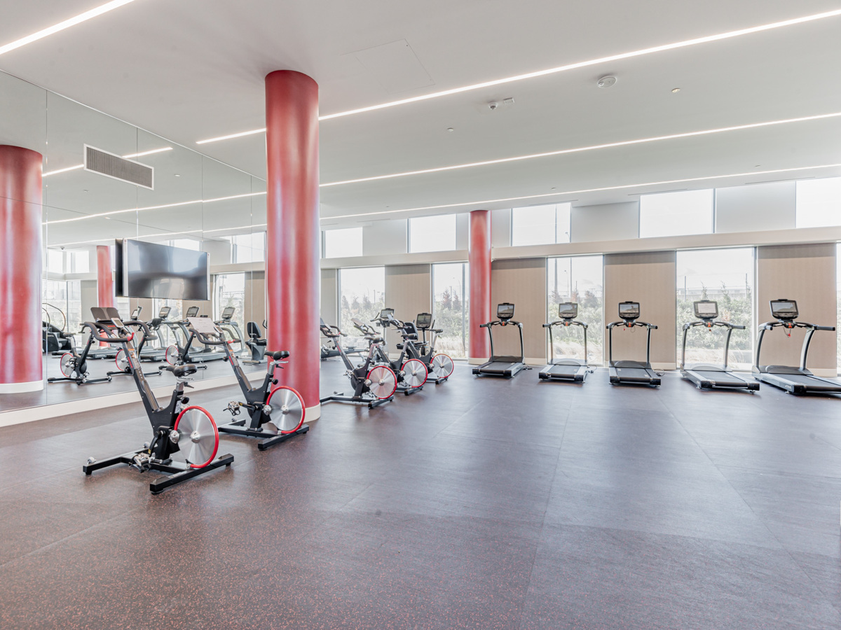Large condo gym with treadmills and exercise bikes.