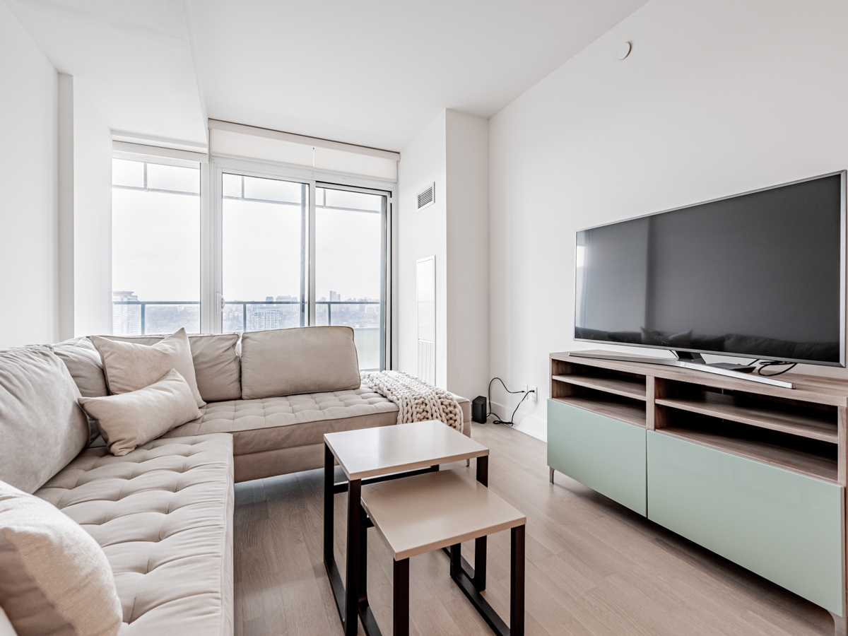 200 Bloor St W Unit 2405 open-concept living room with sectional, coffee table and TV stand.