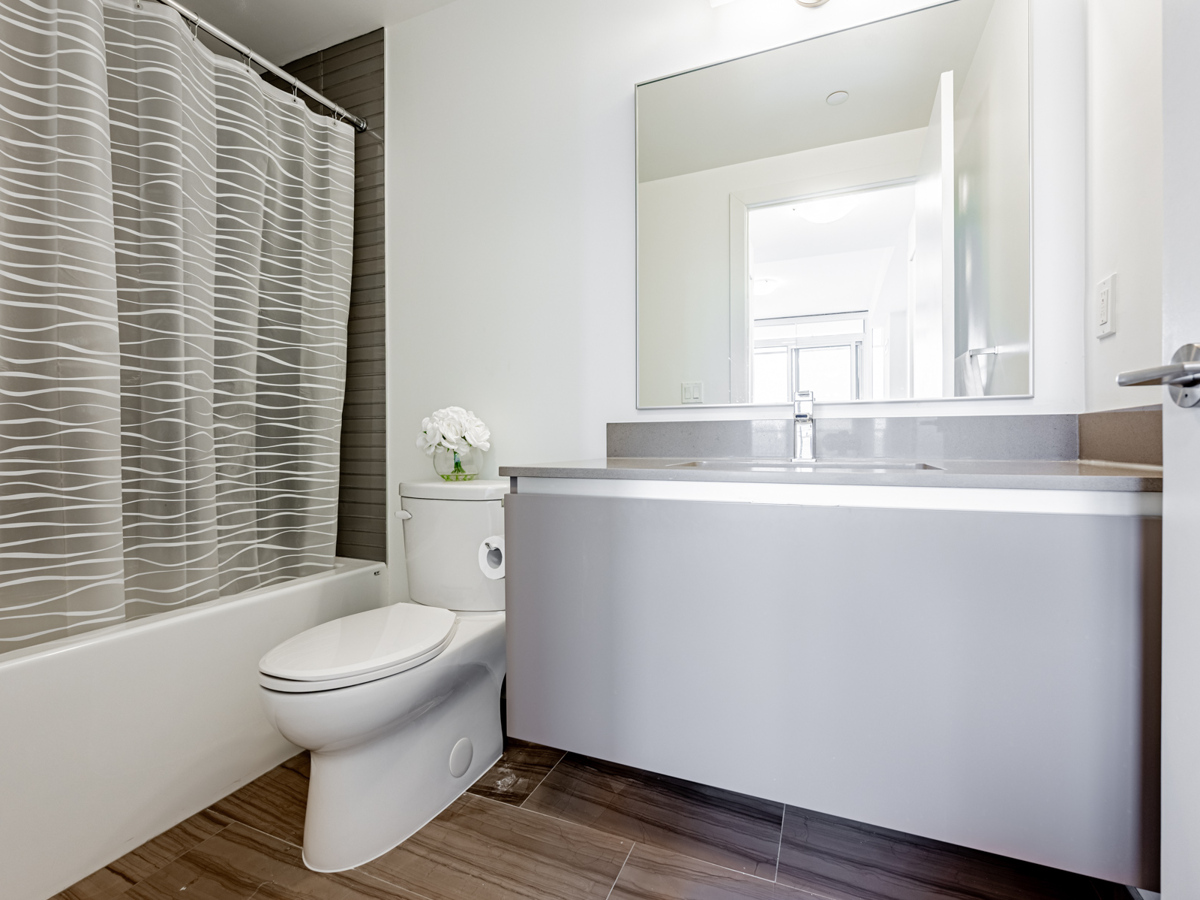 4-piece ensuite bath with wall-mounted vanity, storage cabinets, large mirror and soaker tub.