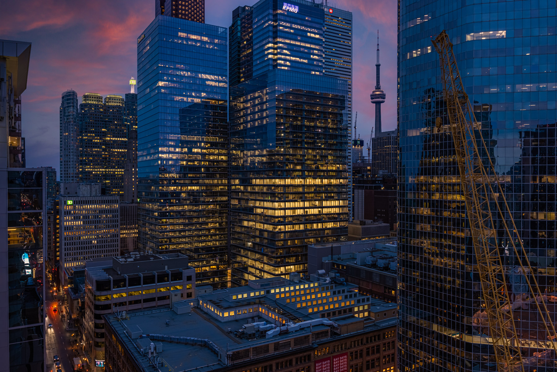 CN Tower rising between buildings.