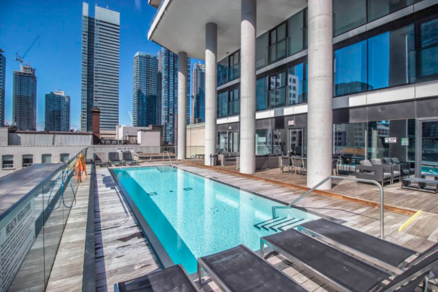 Rooftop pool with chaise lounges at Theatre Park condos.