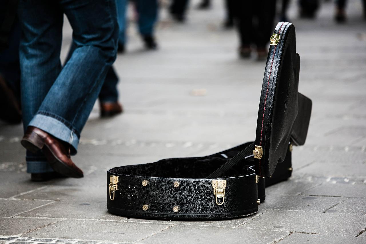 Guitar case on pavement belonging to street performer.