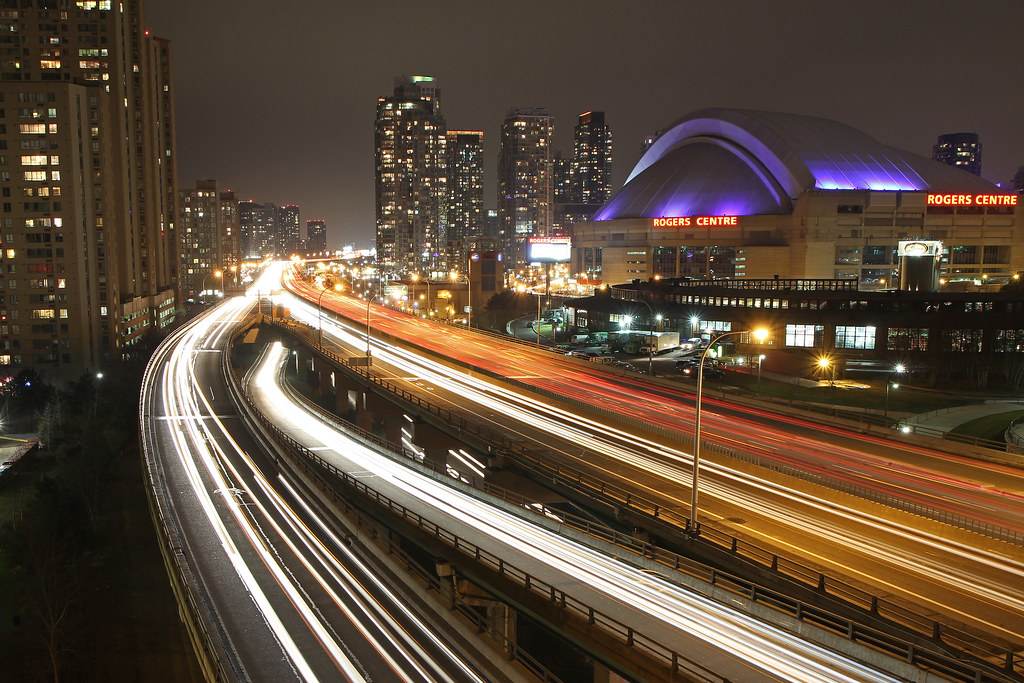 Traffic light trails along Toronto highway in front of Rogers Centre.