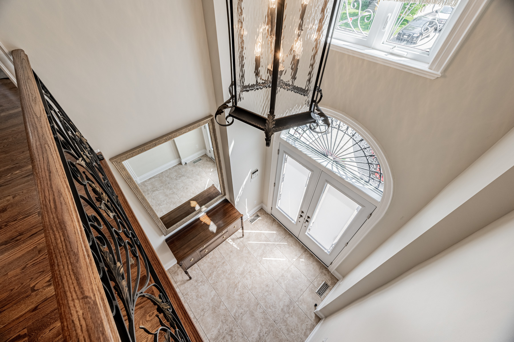 Foyer with double doors, elliptical windows, 18-foot ceiling and chandelier.