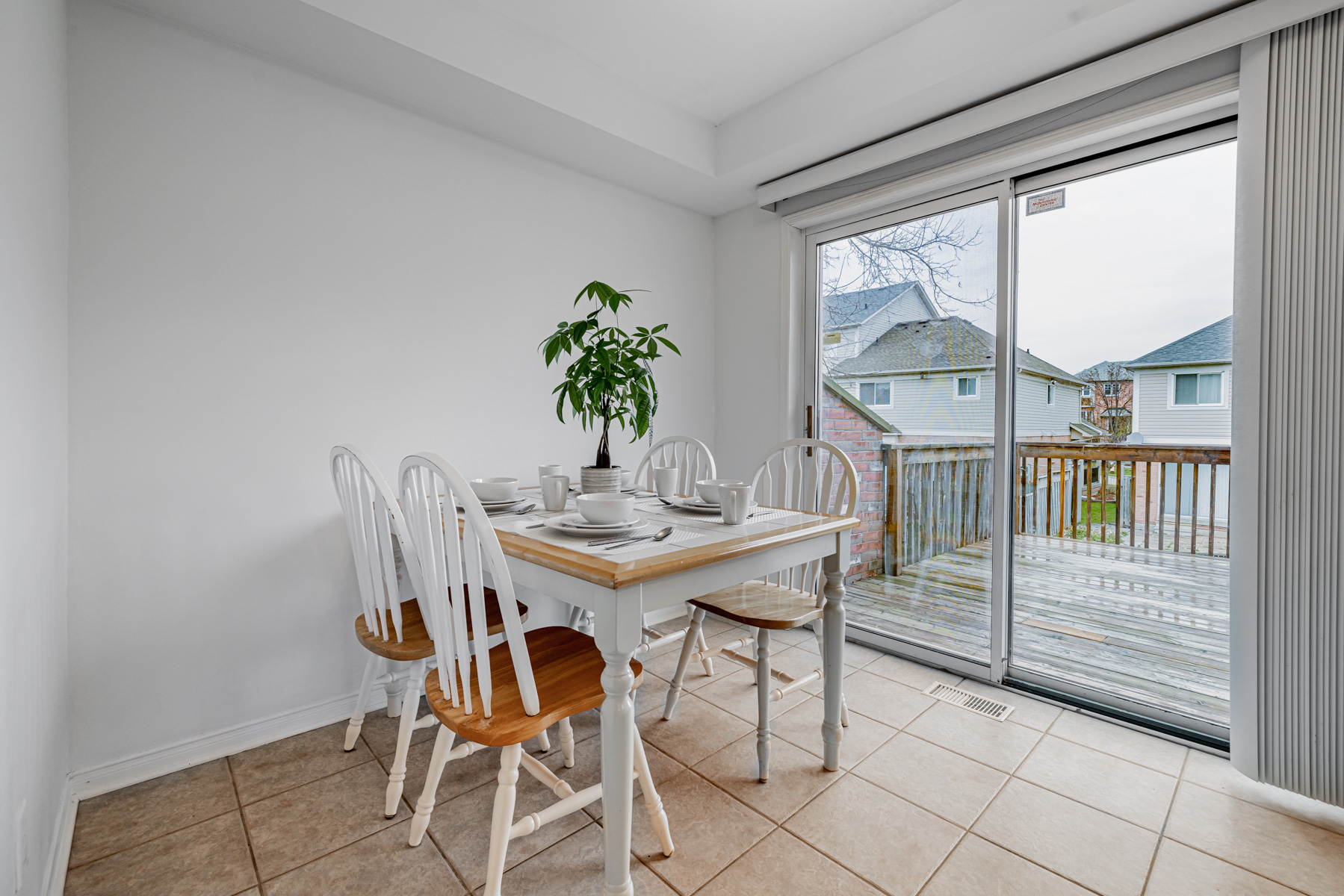 10. 77 Schouten Crescent Breakfast area dining table chairs view of backyard deck 77 Schouten Cres breakfast book with dining table, chairs and view of backyard.