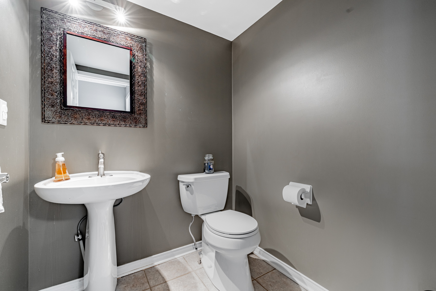 Powder room with dark gray walls and thick mirror frame – 77 Schouten Cres.