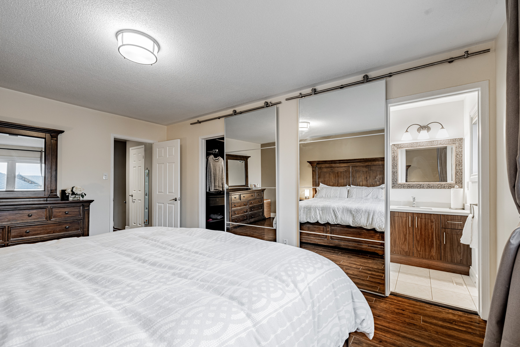 13. Walk in closet ensuite bath mirror doors Walk-in closet and ensuite bath with mirror doors.