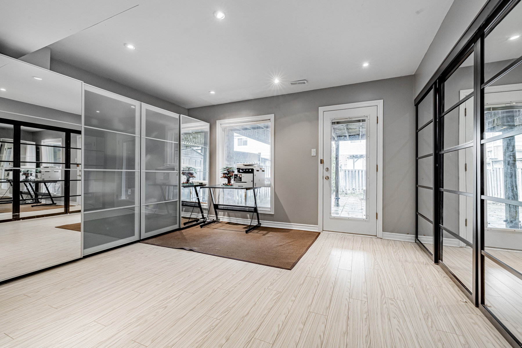 19. Basement with built in shelves laminate floors glass doors large window potlights Basement with built-in shelves, laminate floors, large window, sliding glass doors and pot-lights.