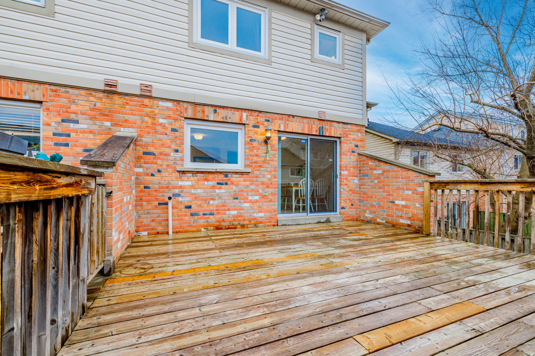 22. 77 Schouten Crescent wood deck with red brick wall Wooden deck with red-brick wall and wood rails.